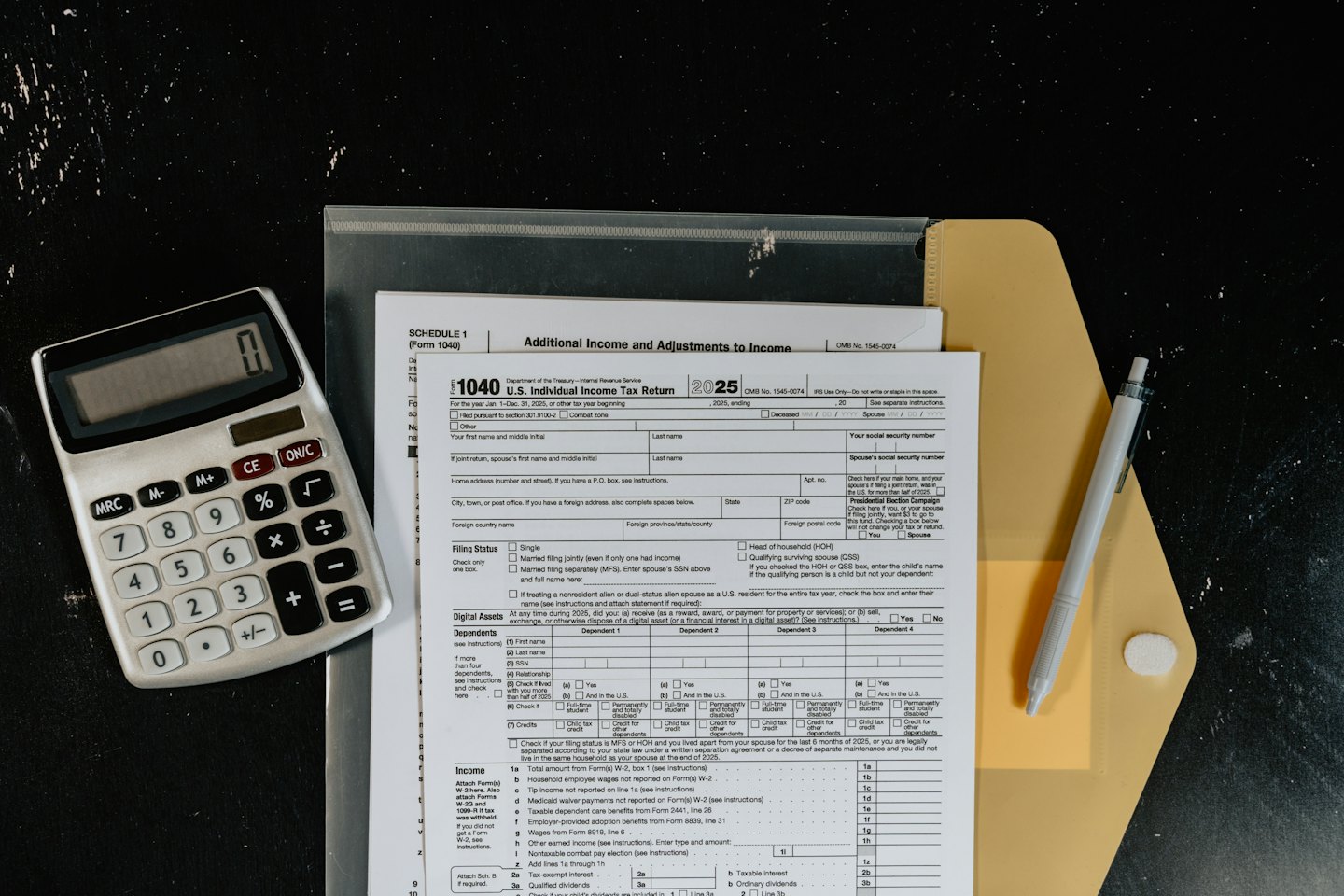 Formularios de impuestos de EE. UU., calculadora y bolígrafo sobre un escritorio.